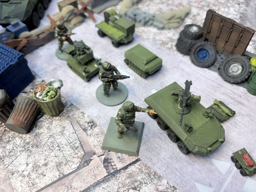 Infantry advancing with 3D-printed UGVs through a rubble street on the Skirmish table