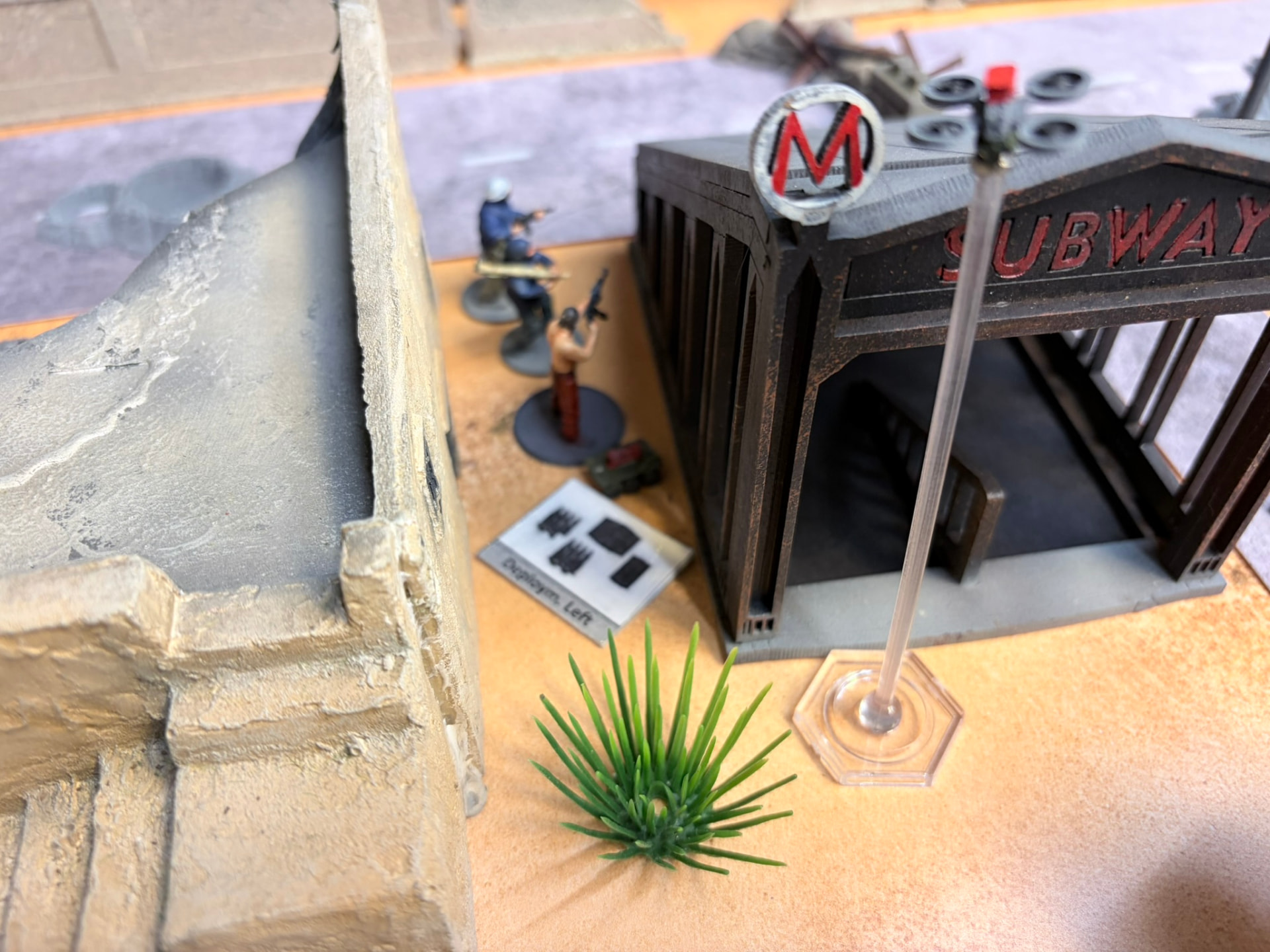Fighters taking cover between a ruined building and a subway entrance under a hovering quadcopter